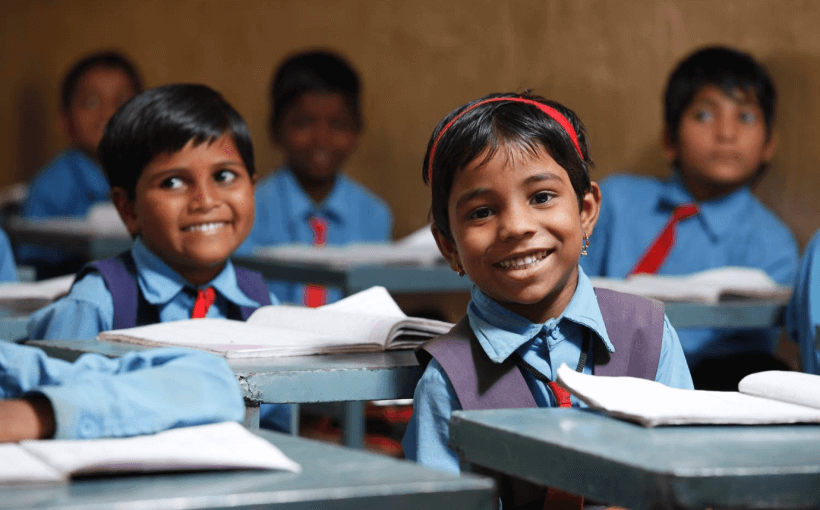 Village children in school uniforms smiling happily at school