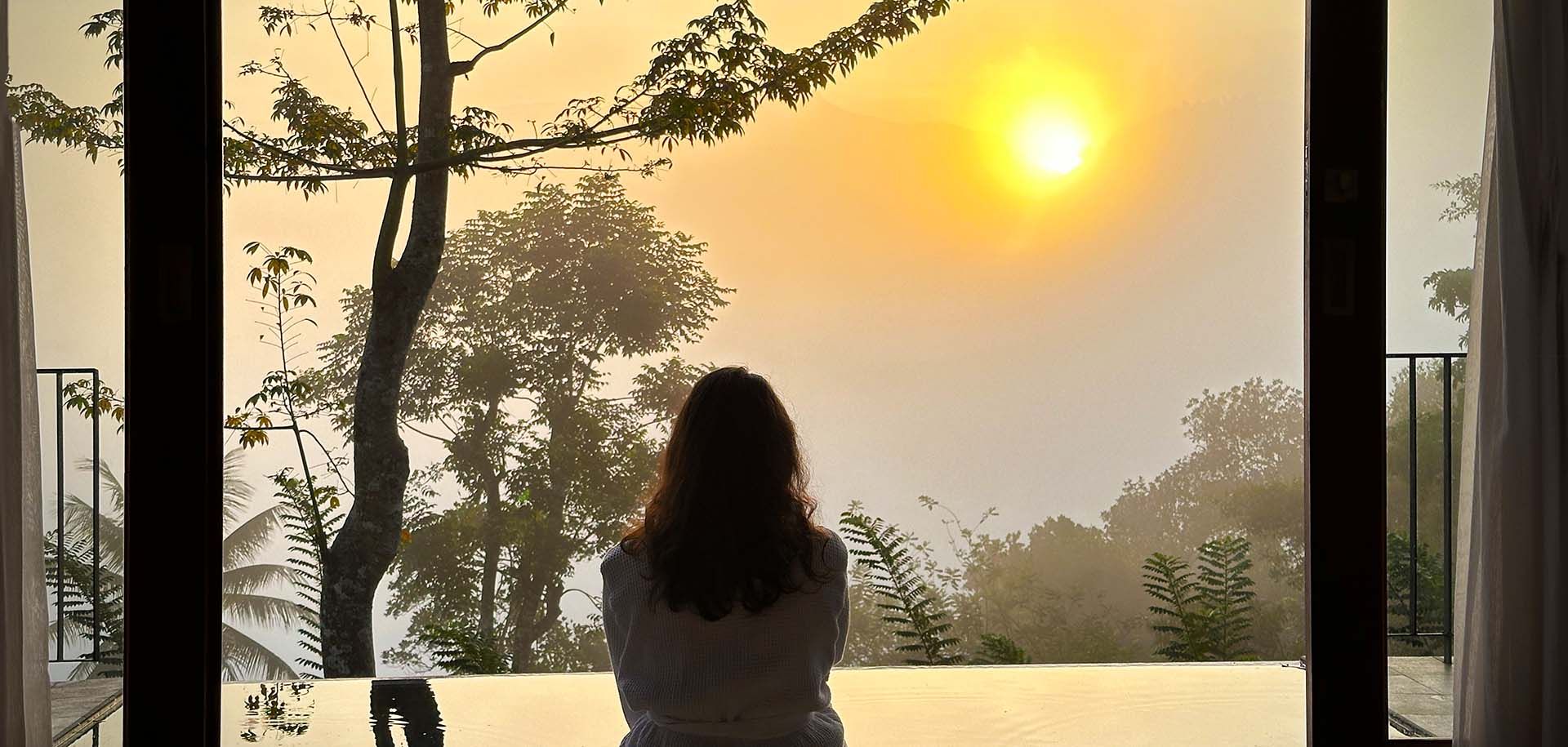 Guest enjoying a peaceful sunset from a villa at Aarunya Nature Resort