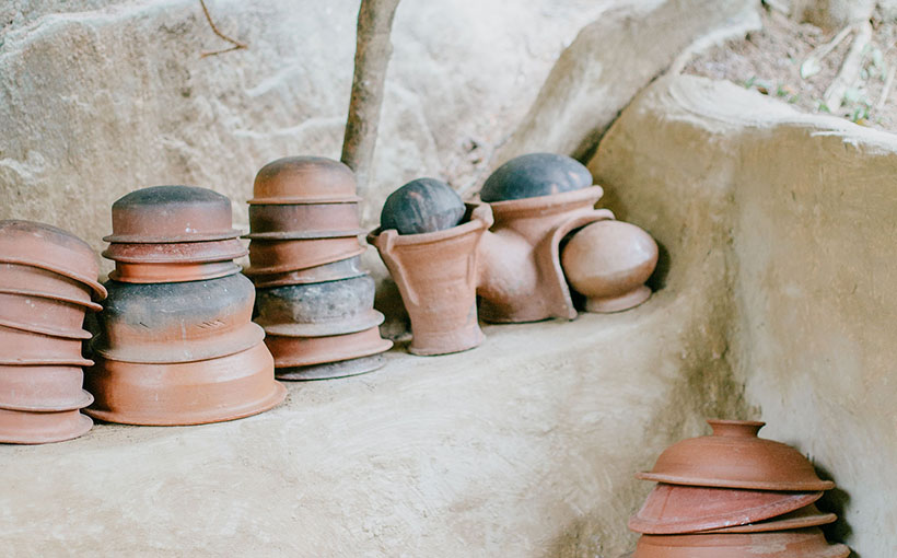 Traditional Sri Lankan kitchen items laid out on a stone ledge