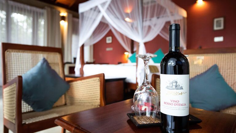 Wine bottle with a glass at Aarunya Nature Resort Villa