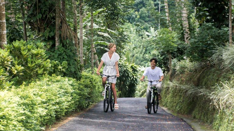 Couple cycling on a scenic trail at Aarunya Nature Resort
