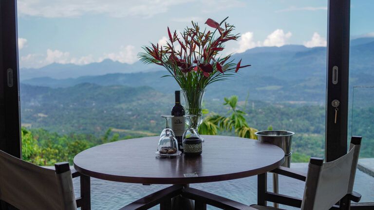 Dining setup with welcome wine and scenic view at Aarunya Nature Resort