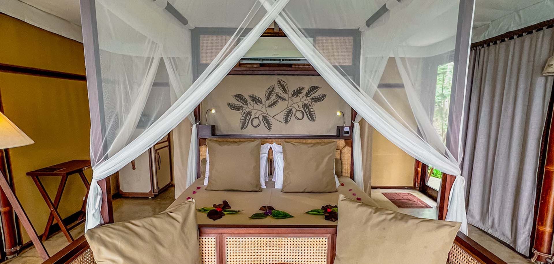 Closeup view of a bed in a Aarunya Nature Resort villa