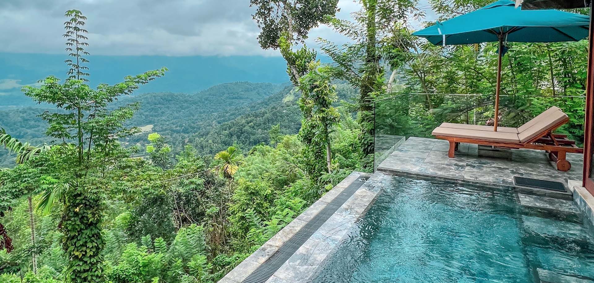 Outdoor pool and loungers with nature views at Aarunya Nature Resort