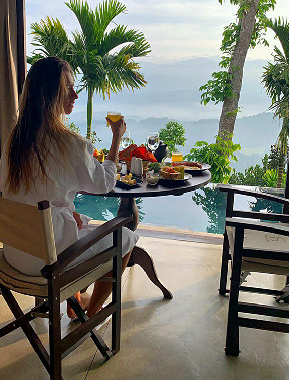 Guest dining with a poolside view from the villa at Aarunya Nature Resort
