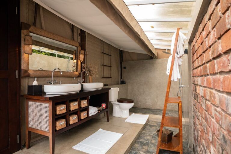 Bathroom with dual sinks and premium amenities at Aarunya Nature Resort