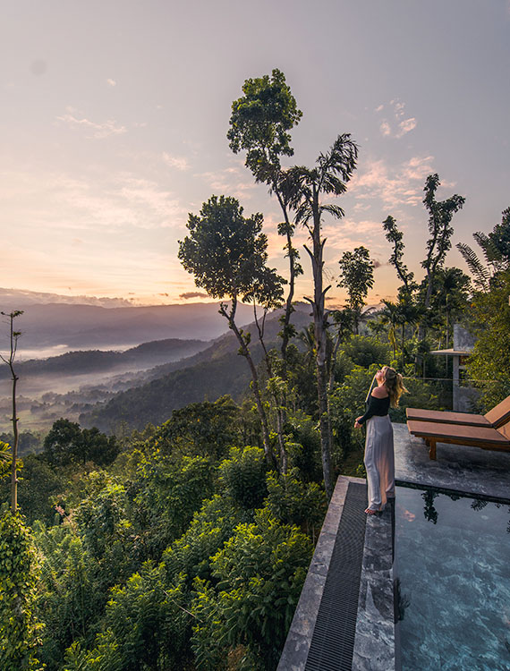 Guest enjoying scenery from edge of the infinity pool at Aarunya