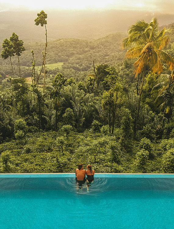 Couple enjoying nature views from the infinity pool at Aarunya Nature Resort