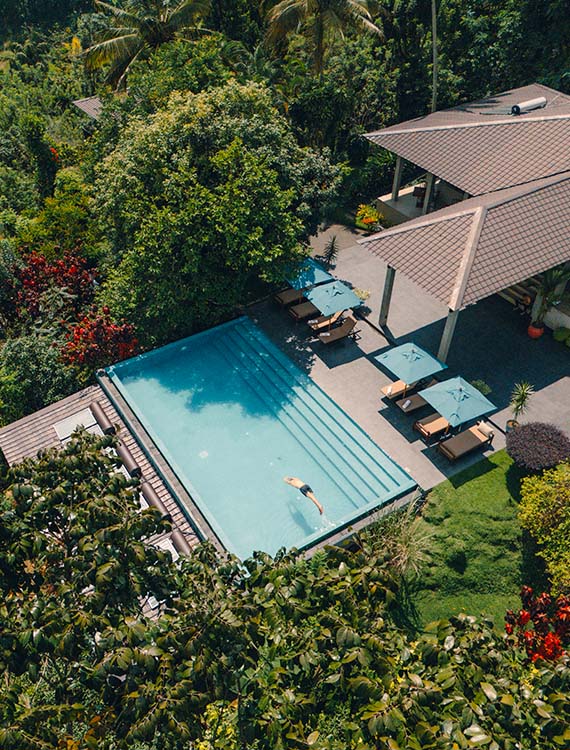 Aerial view of a guest diving into the pool at Aarunya Nature Resort