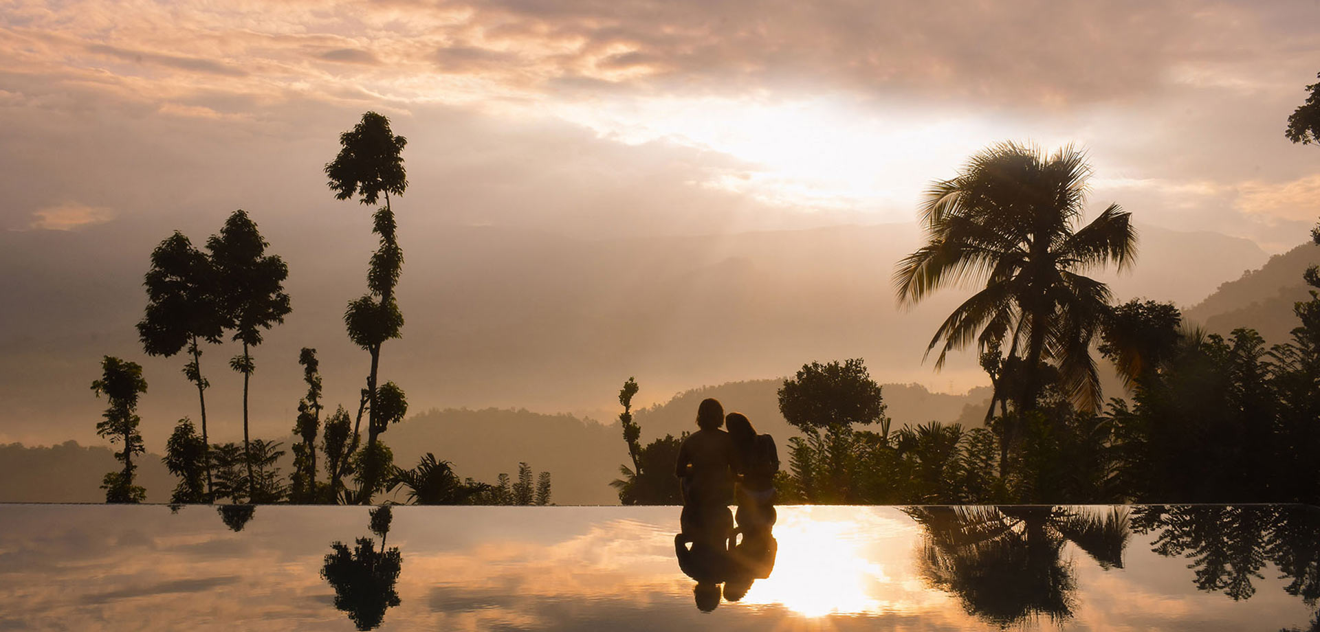 Couple enjoying a romantic sunset view in the infinity pool at Aarunya Nature Resort