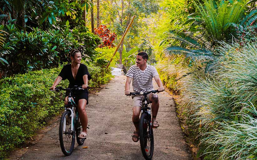 Couple cycling on a scenic trail at Aarunya Nature Resort