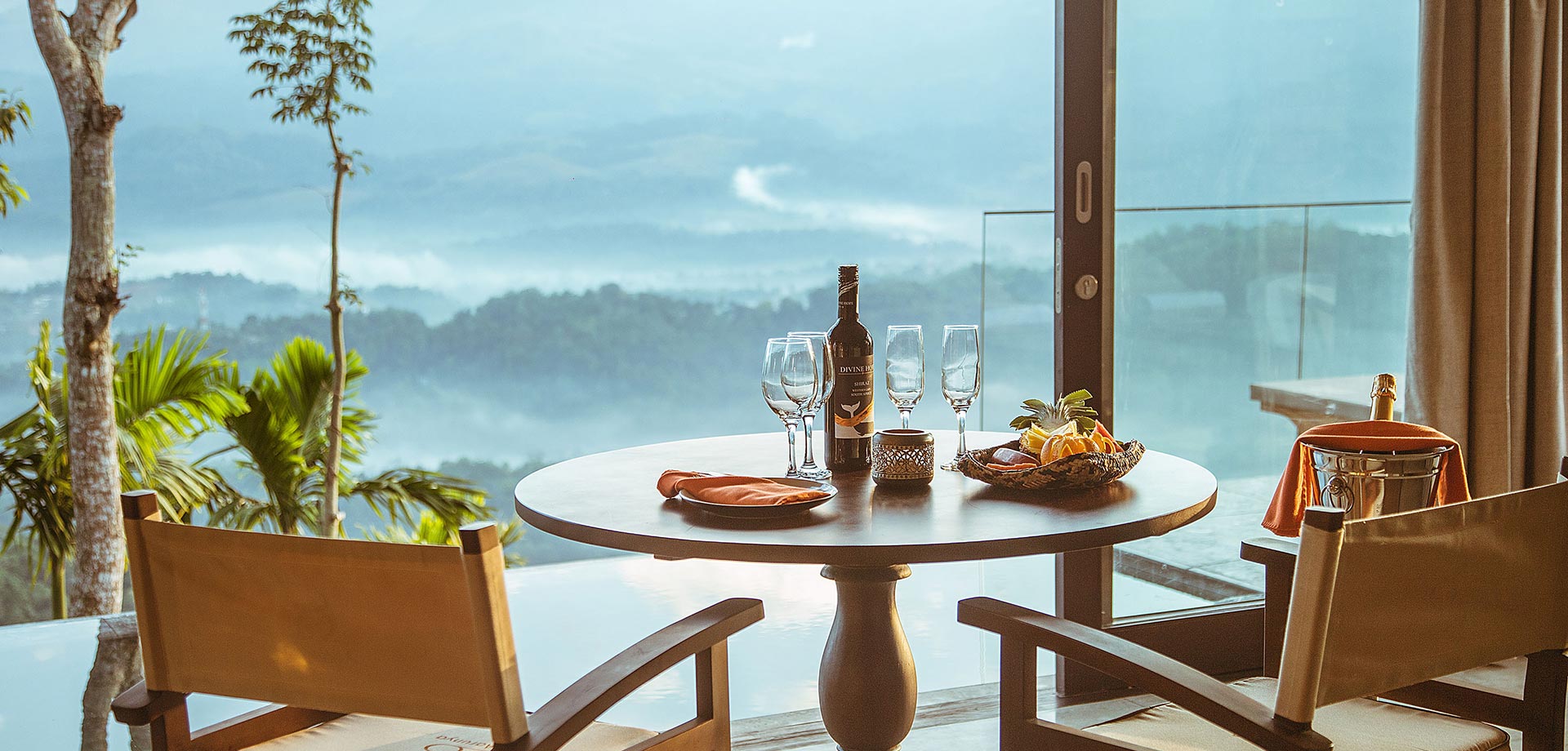 Dining setup with welcome wine and scenic view at Aarunya Nature Resort