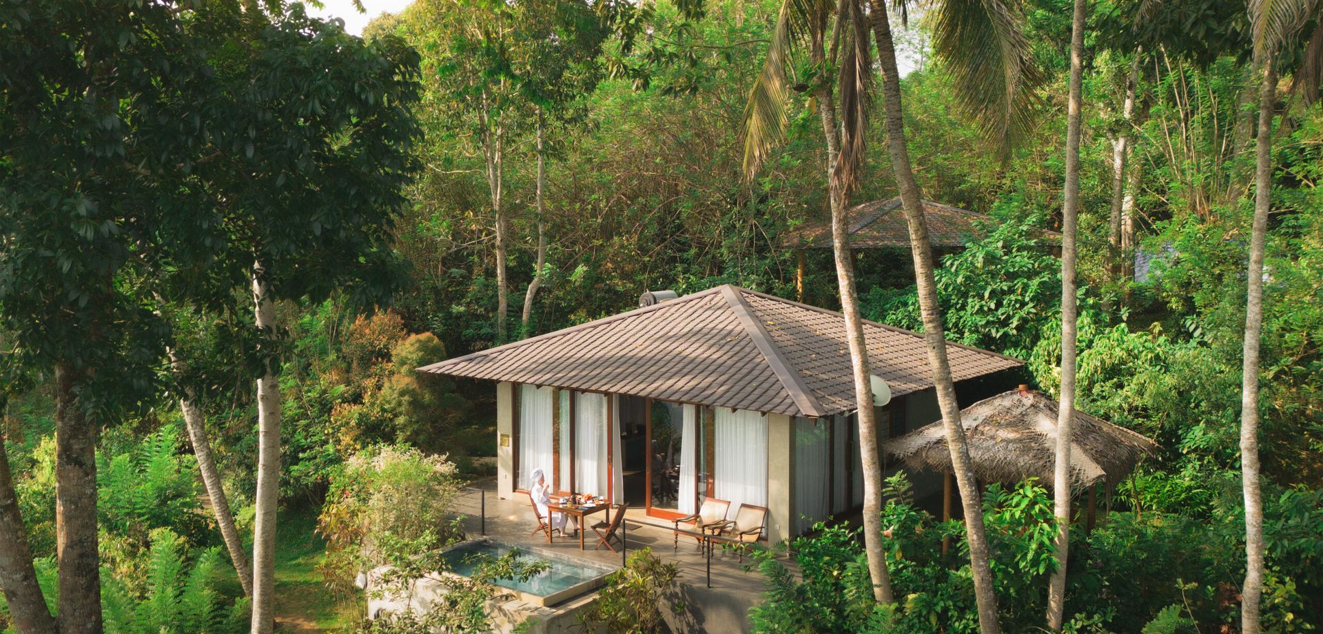 Far shot of guest enjoying tea at a villa from Aarunya Resort