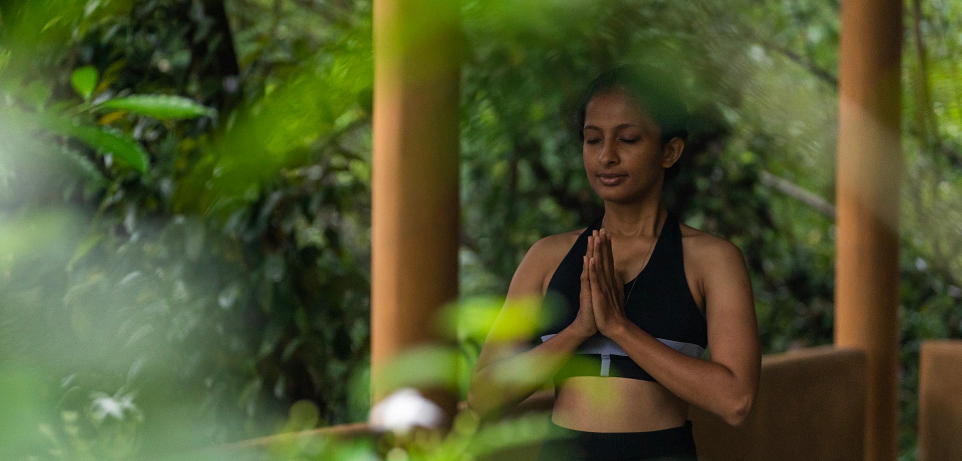 Guest practicing yoga surrounded by green nature at Aarunya Nature Resort
