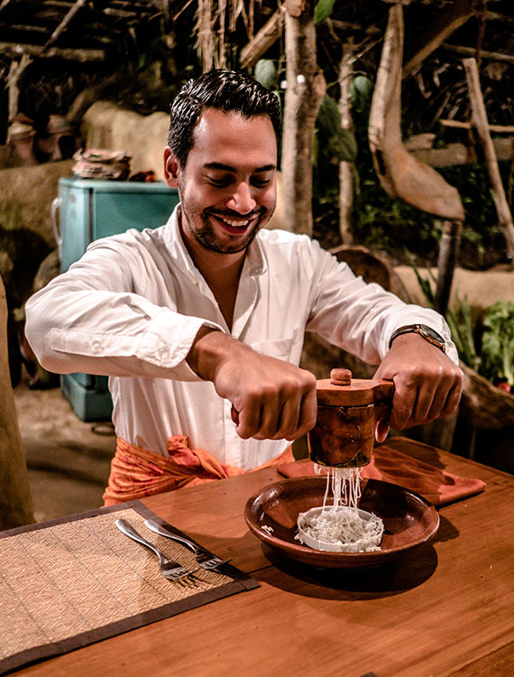 Guest preparing string hoppers during cooking class at Aarunya Nature Resort
