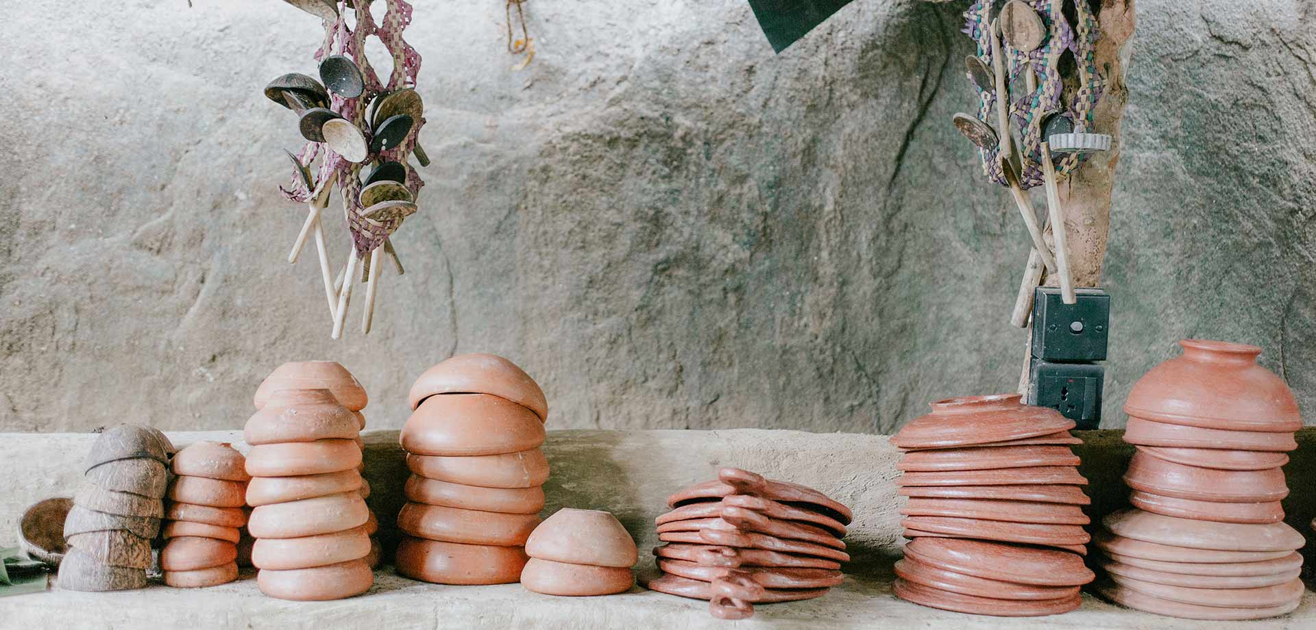 Traditional Sri Lankan kitchen items laid out on a stone ledge