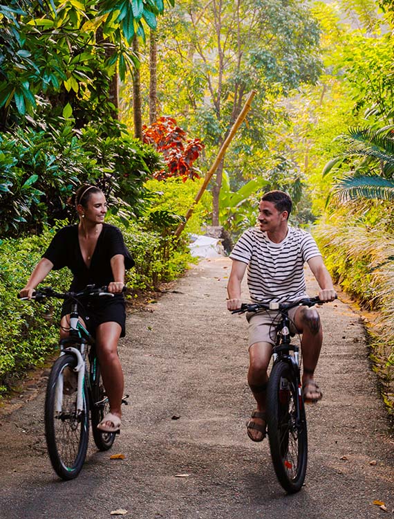 Couple cycling on a scenic trail at Aarunya Nature Resort