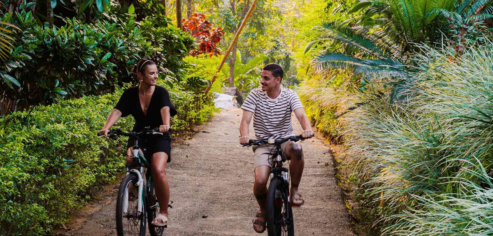 Couple cycling on a scenic trail at Aarunya Nature Resort