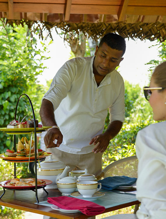 Waiter explaining to guest about high tea spread at Aarunya