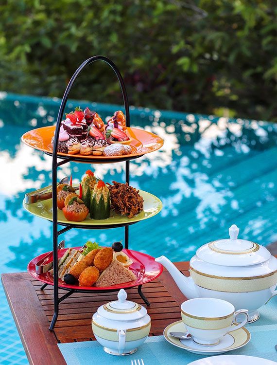 High tea platter with Ceylon tea by the pool at Aarunya Nature Resort