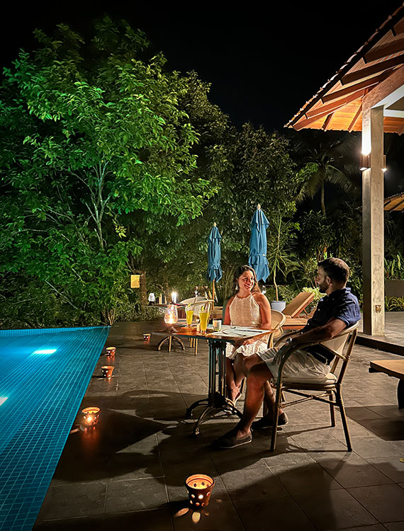 Couple enjoying a romantic poolside dinner at Aarunya Resort