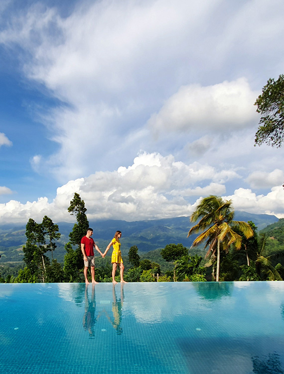 Couple walking alongside the infinity pool edge at Aarunya Nature Resort