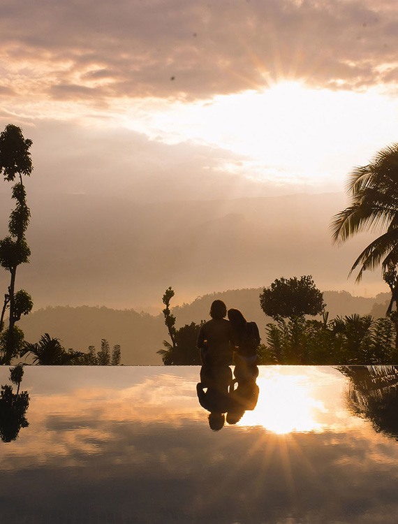 Couple enjoying a romantic sunset view in the infinity pool at Aarunya Nature Resort