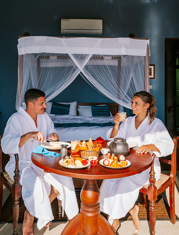 Couple enjoying an in-room dining experience at the Aarunya Nature Resort Villa