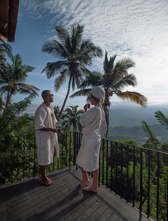 Couple enjoying view from the balcony while sipping a cup of tea at Aarunya