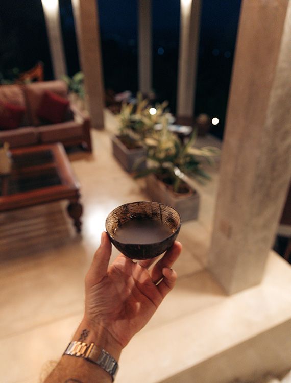 Holding fresh toddy in a coconut shell at Aarunya Nature Resort
