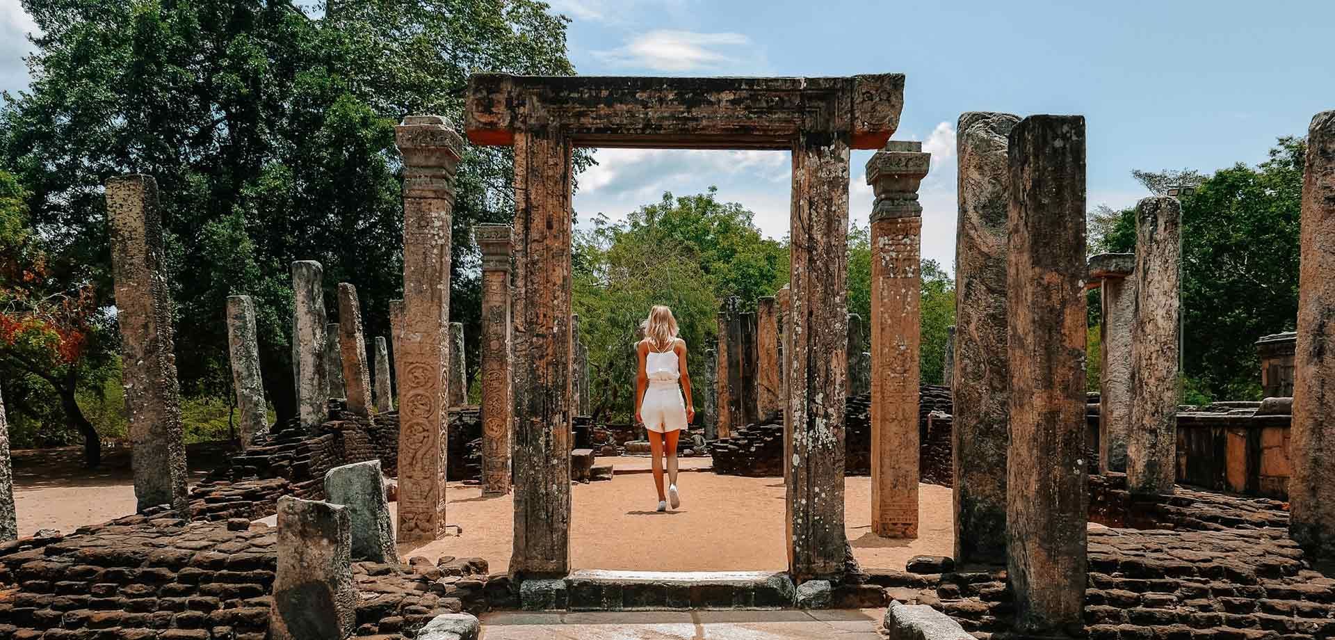 Tourist walking through Polonnaruwa ancient city ruins