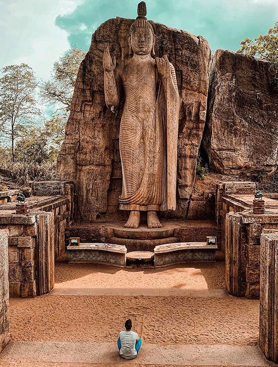 Avukana Buddha statue with worshiping man seated in front