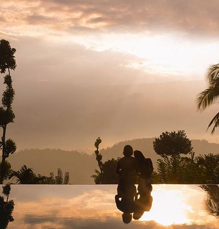 Couple enjoying a romantic sunset view in the infinity pool at Aarunya Nature Resort
