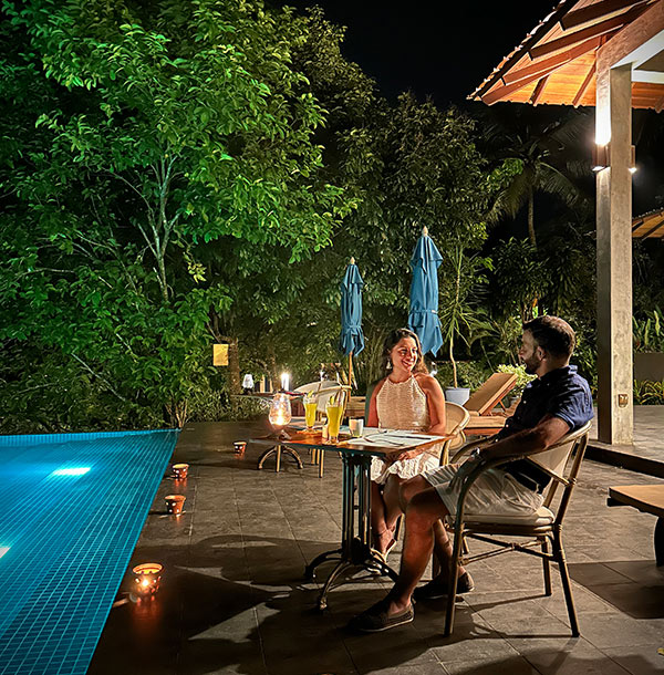 Couple enjoying poolside dining at Aarunya Nature Resort