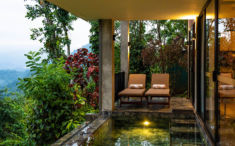 Outdoor verandah with chairs and pool at Aarunya Nature Resort Villa