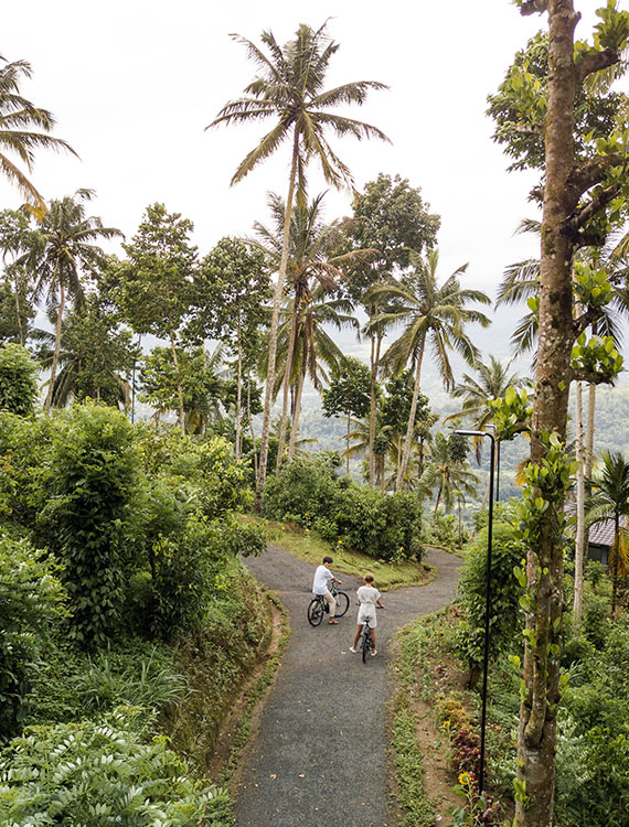 Aerial view of a couple cycling through the scenic hills at Aarunya Nature Resort